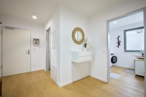 a white room with a sink and a mirror at Ferienwohnung Schwarmstedt in Schwarmstedt +25 photos