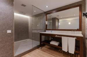 een badkamer met een douche, een wastafel en een spiegel bij Magnolia Hotel - Adults Only in Salou