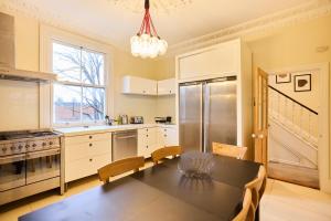 a kitchen with a dining room table and a refrigerator at The Peckham Hideaway - Bright 3BDR Flat in London