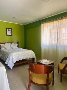 1 dormitorio con 1 cama, 1 mesa y 1 silla en RESORT ALAPA, en Huancayo