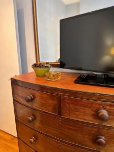 a wooden dresser with a television on top of it at Spacious Belsize Park apartment close to station in London