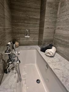 a bath tub with a faucet in a bathroom at Spacious Belsize Park apartment close to station in London