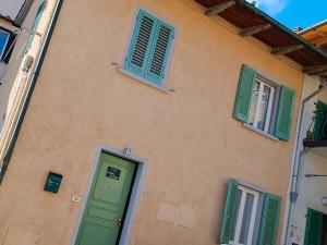 un bâtiment avec des portes et des fenêtres vertes dans l'établissement La casetta del poggio, à Poggio a Caiano