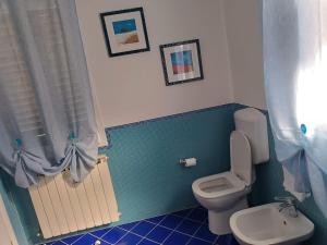 a bathroom with a toilet and blue tile at La casetta del poggio in Poggio a Caiano +10 photos