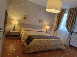a bedroom with a bed and two lamps and a window at La casetta del poggio in Poggio a Caiano