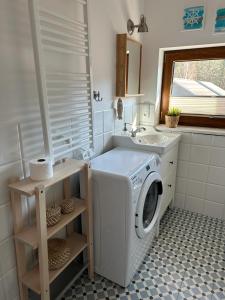 y baño con lavabo y lavadora. en Apartament Premium Łeba en Żarnowska