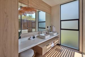 baño con 2 lavabos y espejo grande en Epic Tamarindo Boutique Hotel en Villarreal