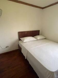 2 Betten in einem Zimmer mit weißer Bettwäsche und Kissen in der Unterkunft Apartamento con piscina en jarabacoa in Jarabacoa