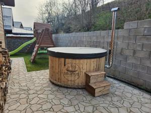 a barrel sitting on a patio next to a wall at Chalet Fiona with jacuzzi in Mýto pod Ďumbierom