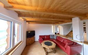 - un salon avec un canapé rouge et une télévision dans l'établissement Ferienhaus Maliet - Spacious Holiday Home with 4 Double Rooms, à Pany