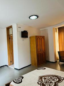 Habitación con cama y TV en la pared. en Goza Guest House 22, en Addis Ababa