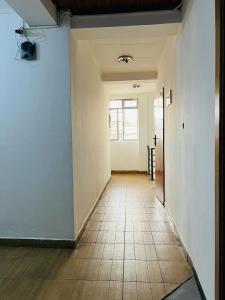 um corredor vazio com piso em azulejo e uma janela em Goza Guest House 22 em Addis Ababa