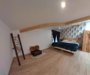 Schlafzimmer mit einem Bett und Holzboden in der Unterkunft Le pat' toit in Aurec-sur-Loire