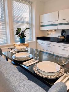 a kitchen with a table with plates and wine glasses at Spacious Belsize Park apartment close to station in London
