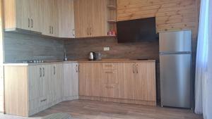 cocina con armarios de madera y nevera de acero inoxidable en tsilo, en Batumi