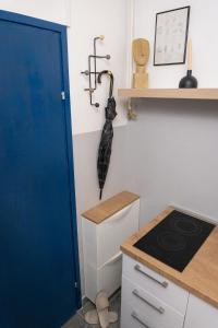 a kitchen with a blue door and an umbrella on the wall at Apartment City Cat in Križevci
