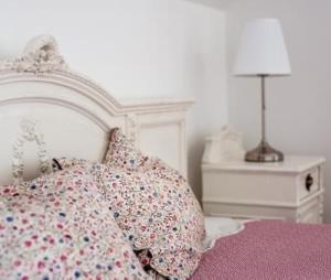 a bedroom with a bed with pillows and a night stand at Villa Portico in Badacsonytomaj