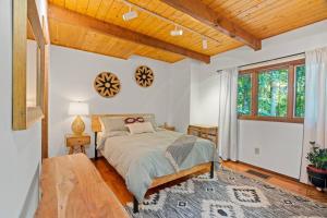 1 dormitorio con cama y techo de madera en The Green Forest Retreat - Kayak, Hot Tub, Sauna en East Stroudsburg