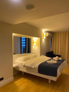 a bedroom with a large bed and a chair at ORBI CITY - Batumi Apartments in Batumi