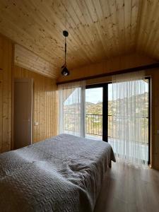 a bedroom with a bed and a large window at B-XON Makhinjauri in Batumi