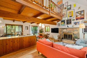 a living room with orange furniture and a stone fireplace at The Green Forest Retreat - Kayak, Hot Tub, Sauna in East Stroudsburg