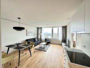 cocina y sala de estar con mesa en 2.5 Room@MydiHei Apartments en Neuhausen am Rheinfall