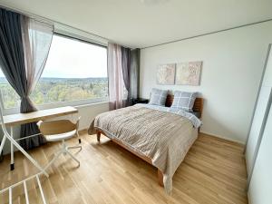 1 dormitorio con cama, escritorio y ventana en 2.5 Room@MydiHei Apartments en Neuhausen am Rheinfall
