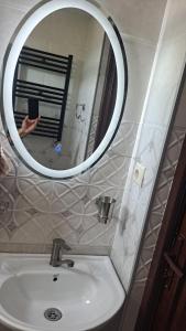 una persona que toma una foto de un espejo de baño en tsilo, en Batumi