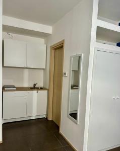 a kitchen with white cabinets and a sink and a mirror at IL RUGGI BB in Salerno