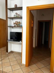 ein Wohnzimmer mit einem TV und einem Flur in der Unterkunft Casa Vacanze Vista al Mar in Marina di Camerota