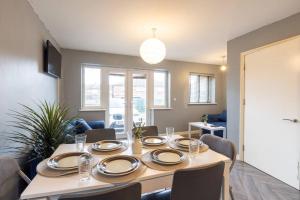 a dining room with a table with plates and chairs at Large Contractor House/ Fits 10/ Free Parking/Discount Long Term Stays in Leeds
