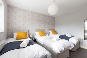 three beds in a room with yellow and white at Large Contractor House/ Fits 10/ Free Parking/Discount Long Term Stays in Leeds