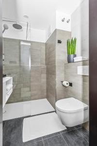 ein Bad mit einem WC und einer Glasdusche in der Unterkunft Nena Apartments München City - NEW OPENING 2024 in München
