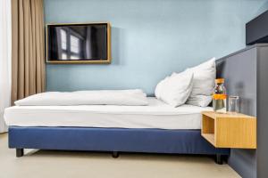 Bett in einem Zimmer mit einem Wandspiegel in der Unterkunft Nena Apartments München City - NEW OPENING 2024 in München