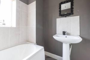 a white bathroom with a sink and a bath tub at Large Contractor House/ Fits 10/ Free Parking/Discount Long Term Stays in Leeds