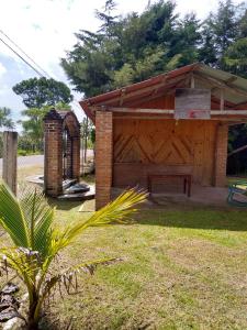 a wooden shed with a bench in a yard at La morada del amigo in La Trinitaria