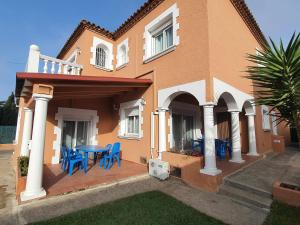 Casa con patio con sillas azules y mesa. en Costa Brava Suites Villa Cèsar, en Calonge