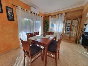 comedor con mesa de madera y sillas en Costa Brava Suites Villa Cèsar, en Calonge