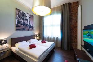 una camera d'albergo con un letto e una televisione di Hotel Volksschule ad Amburgo Altre 36 foto
