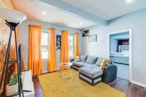 a living room with orange curtains and a couch at Updated Linden Home Visit NYC and Newark! in Linden