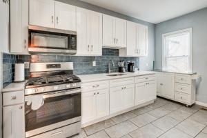 a kitchen with white cabinets and a stove top oven at Updated Linden Home Visit NYC and Newark! in Linden