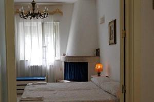 プティニャーノにあるB&B Il Bambùのベッドルーム1室(ベッド1台、窓、シャンデリア付)
