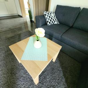 a vase with a flower on a table in a living room at Apartman Mate in Rakovica