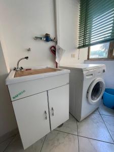 cocina con fregadero y lavadora en Jeranto Apartment, en Piano di Sorrento