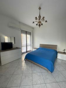 1 dormitorio con 1 cama azul y TV en Jeranto Apartment, en Piano di Sorrento