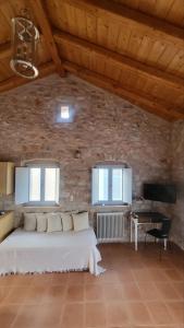 1 dormitorio con 1 cama blanca en una pared de ladrillo en Balcony&Tower, en Areopoli