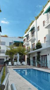 um hotel com piscina em frente a um edifício em Sientoonce em Cartagena das Índias