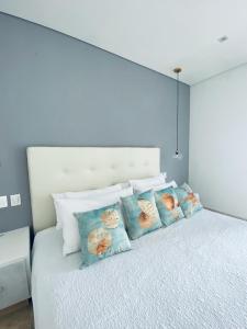 a white bed with four pillows on it at Sientoonce in Cartagena de Indias