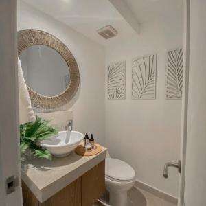 uma casa de banho com um lavatório, um WC e um espelho. em Sientoonce em Cartagena de Indias