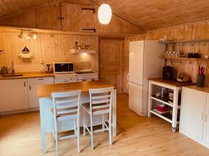 Kosta Bed-Vandrarhem في كوستا: مطبخ مع طاولة وكراسي وثلاجة